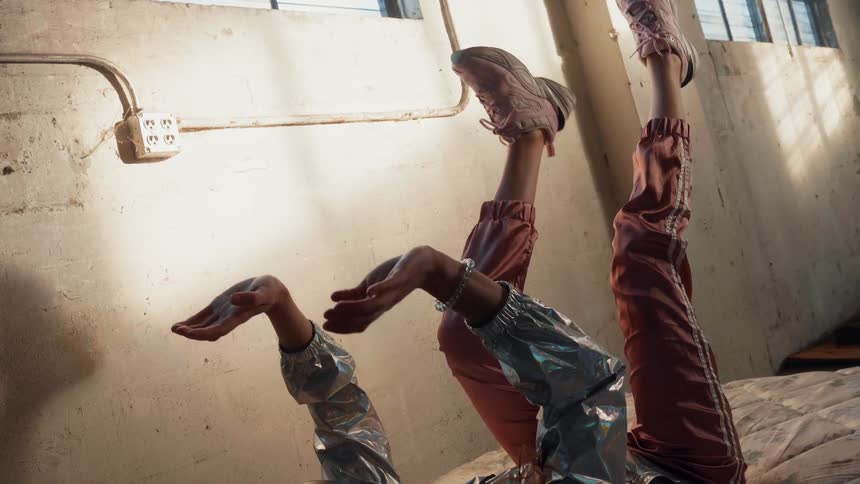 The woman lays in the bed waving her arms and legs up while wearing a virtual reality headset