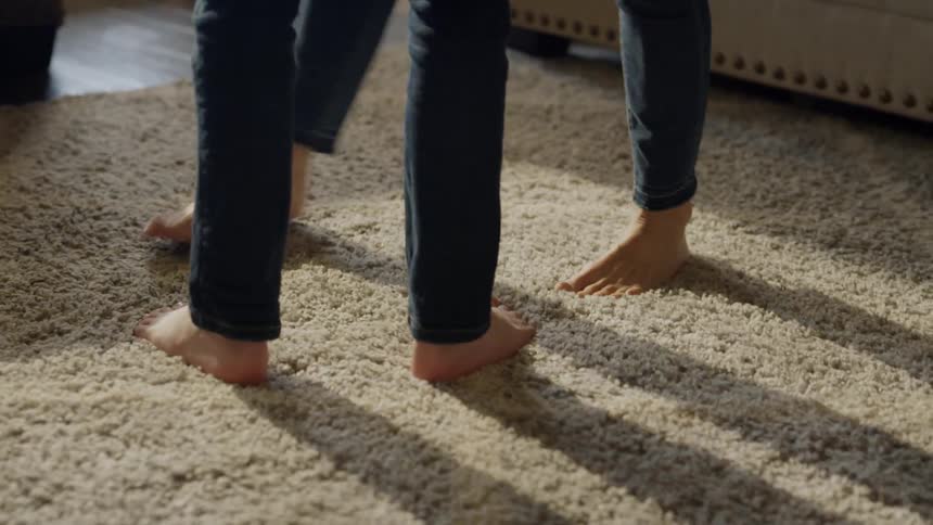 Two people are dancing on the carpet together