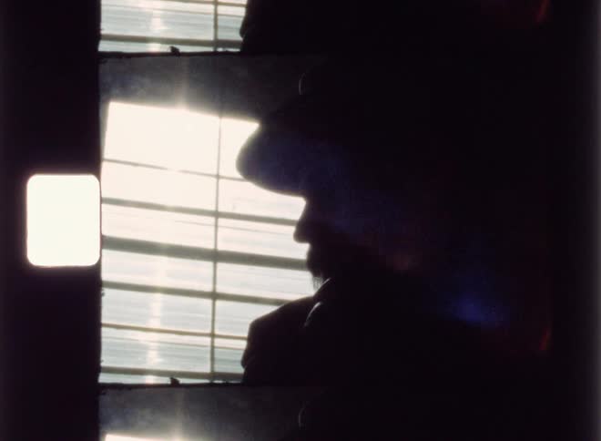 A man stands next to a sunny window