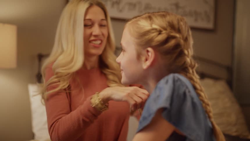 A mother braids her hair as they talk