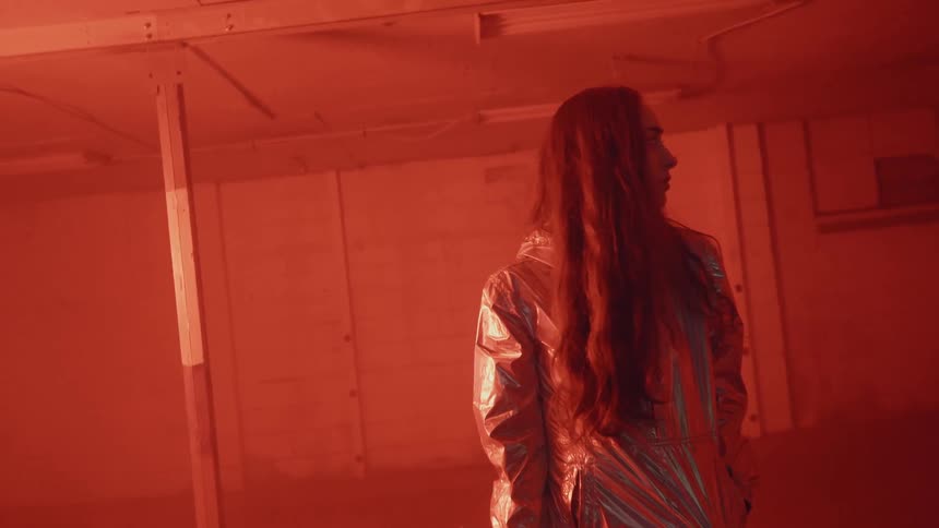 A woman is standing in a room with flashing lights