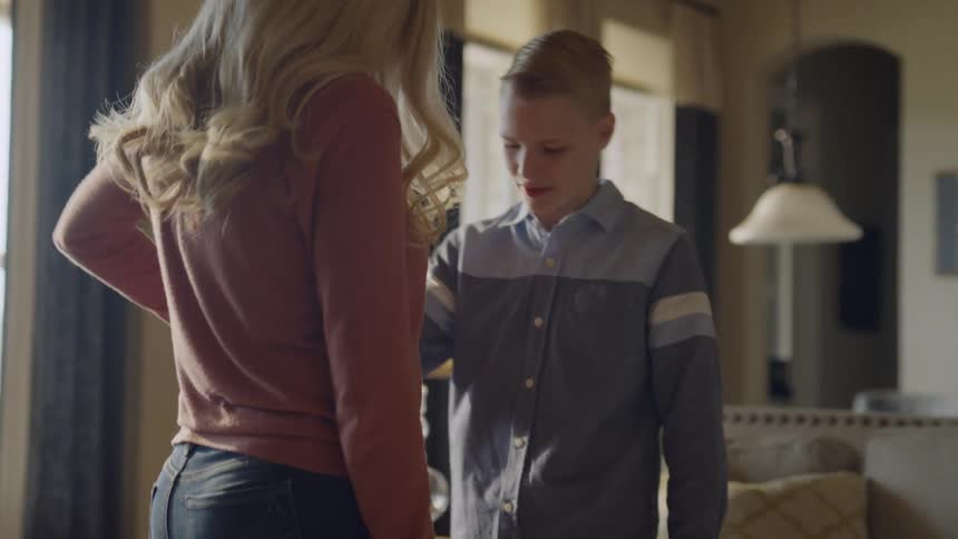 A woman teaches a boy to dance