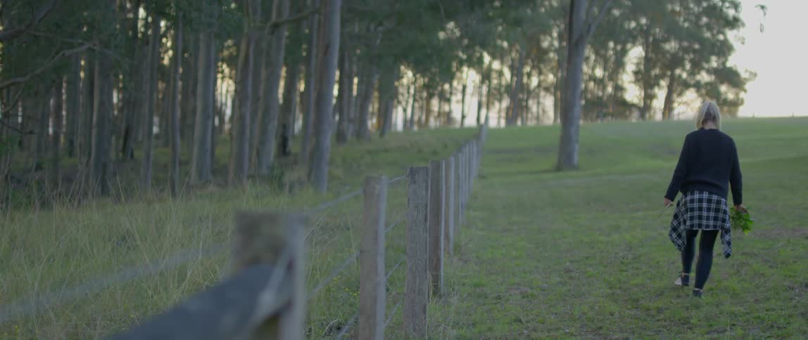A woman is walking in a field