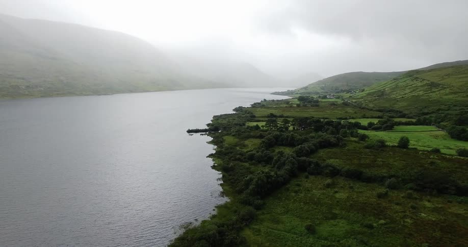 Fog and clouds are hanging over a secluded inlet in daylight