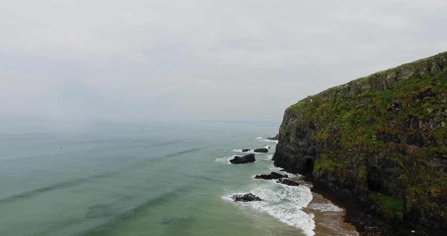 Waves flow towards the tall cliffs