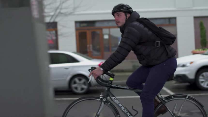 A man is riding his bike down the city street