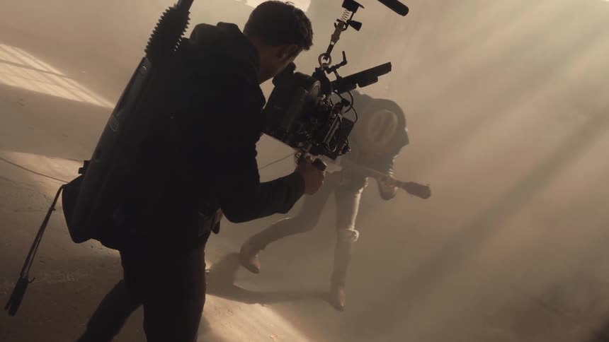 A man is performing with a guitar as he his being filmed