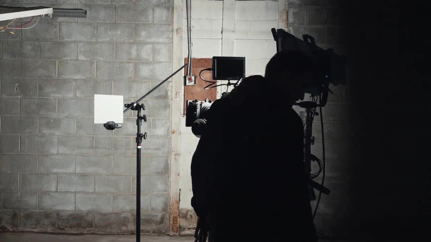 A man is setting up some camera equipment and lights