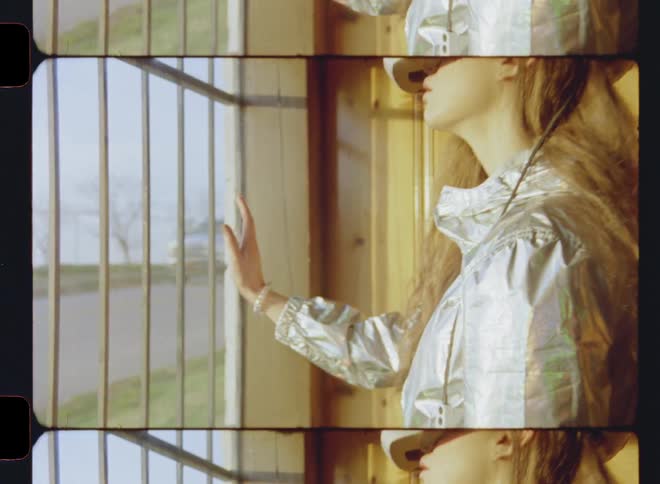 A woman puts her hand up to a window while wearing a virtual reality headset
