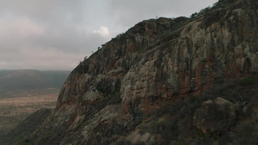 Flying towards the cliff of a desert mountain