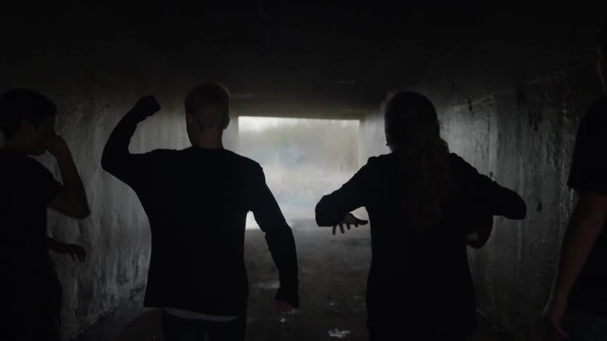 The children run down the dark tunnel towards the exit