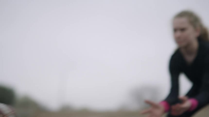 Children play football in a muddy and grassy field