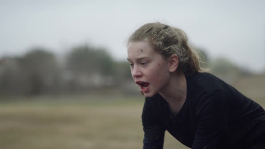 A girl plays football outside