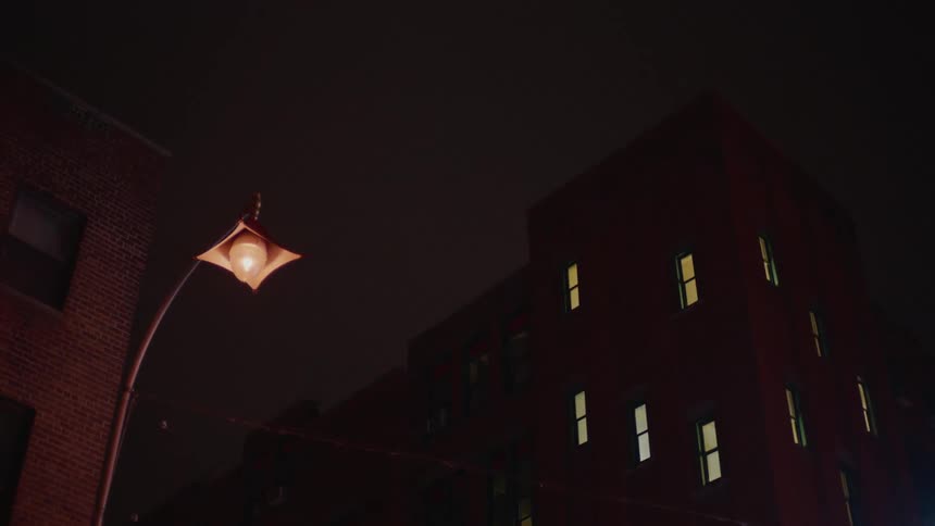 The street lamp is illuminating the street at night