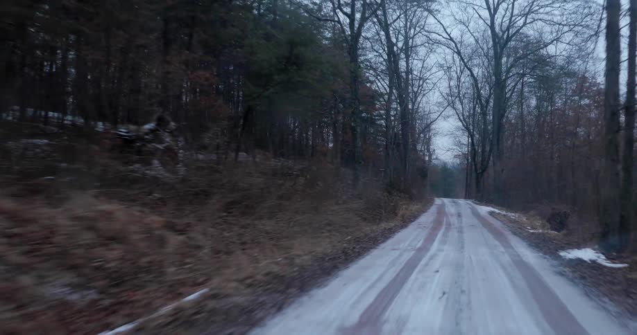 The trail is covered with snow near the forest