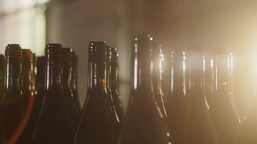 The glass bottles are rotating in the warehouse