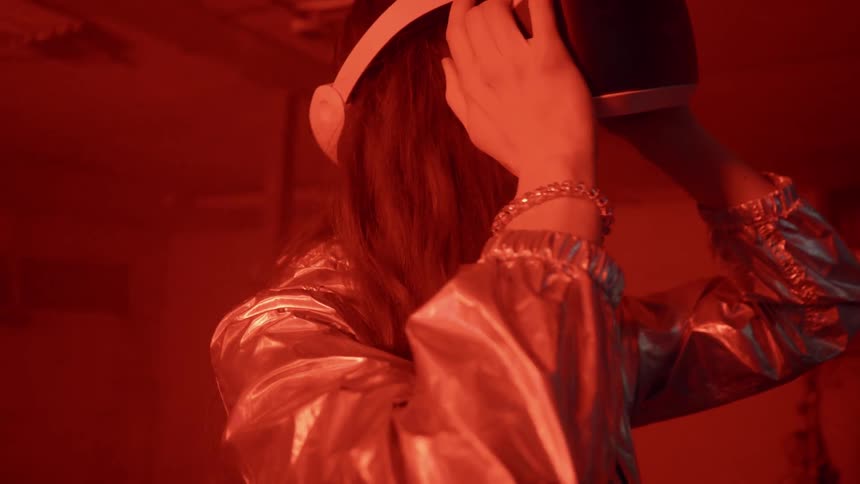 A woman holds her virtual reality headset looking forward