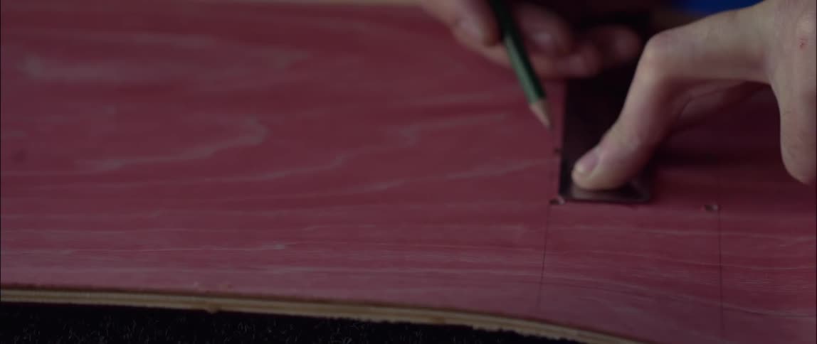 A person uses a ruler to draw a straight line