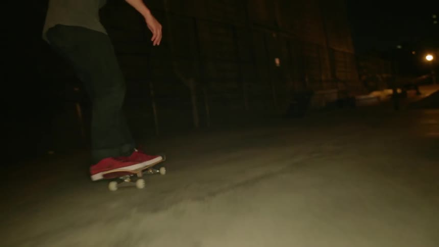 The man is skateboarding and doing tricks at night