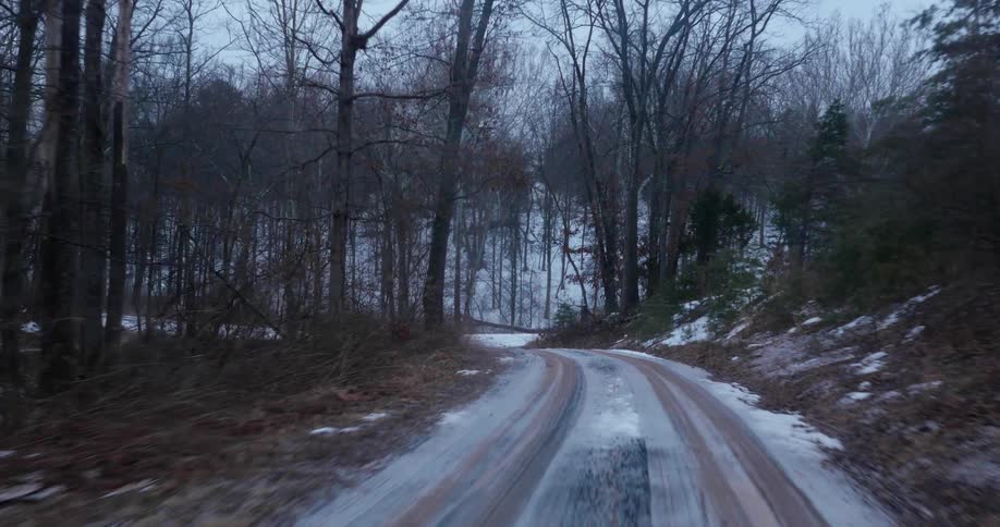 The small road runs through the forest and hills