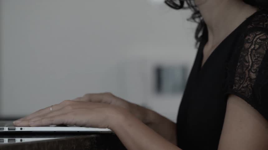 A woman is sitting down using a laptop