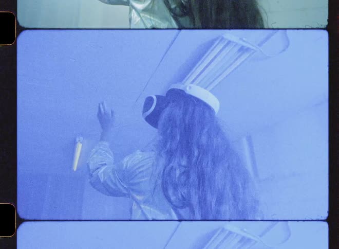 A woman wearing vr glasses reaches up while lights flash