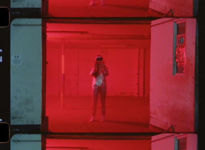 A woman wearing virtual reality goggles stands in a room with flashing lights
