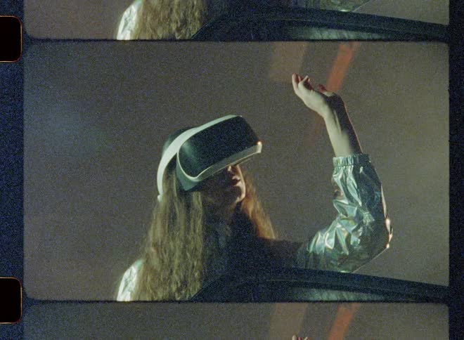 Woman wearing virtual reality headset is reaching out her hand