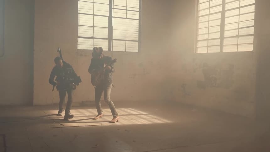 A man runs around a guitar player filming him as he plays