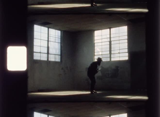 A man is performing in the dark room with a guitar