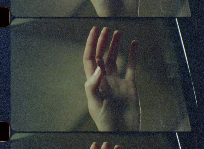 A woman is running her hand down the inside of a car's window