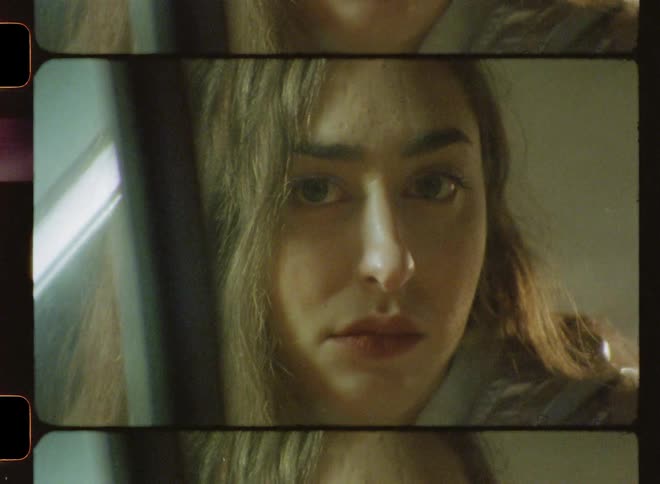 A woman is turning her head and looking forward in daylight
