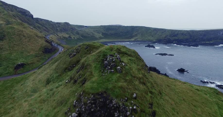 The lake leads to green hills all around
