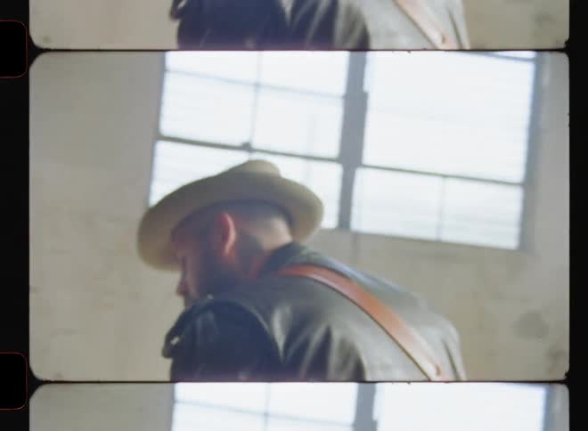 Man in hat jams on an electric guitar