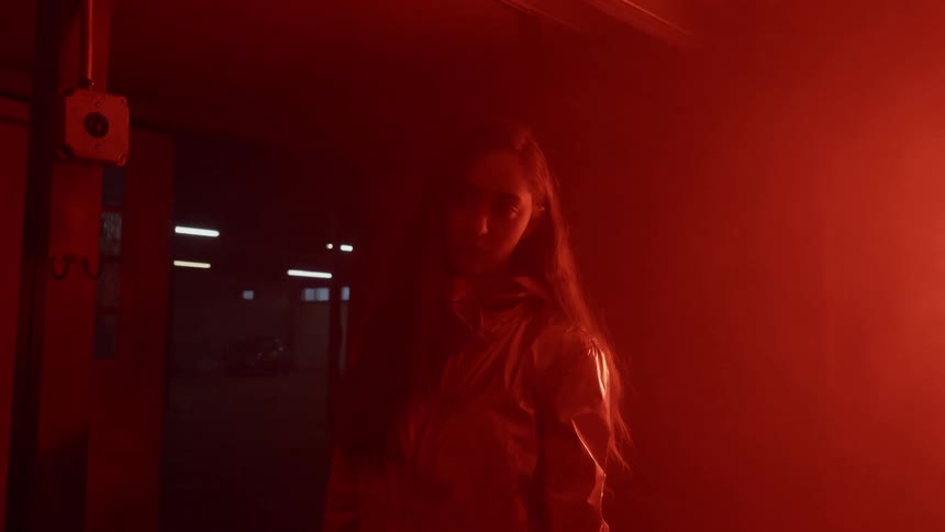 Lights flash around a woman in a warehouse