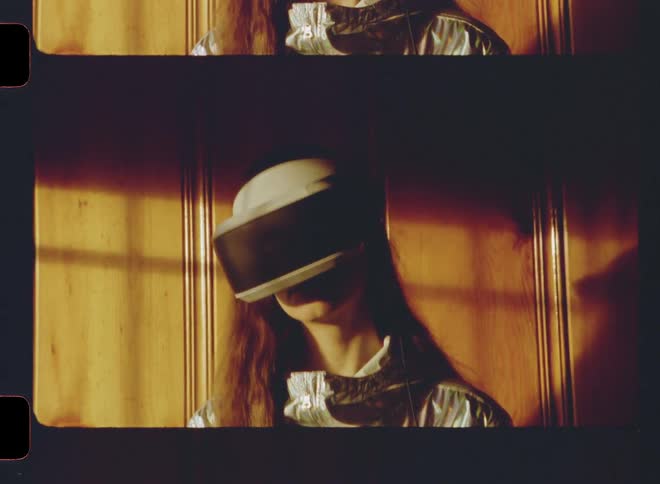 A woman stands in the dark room using a virtual reality headset