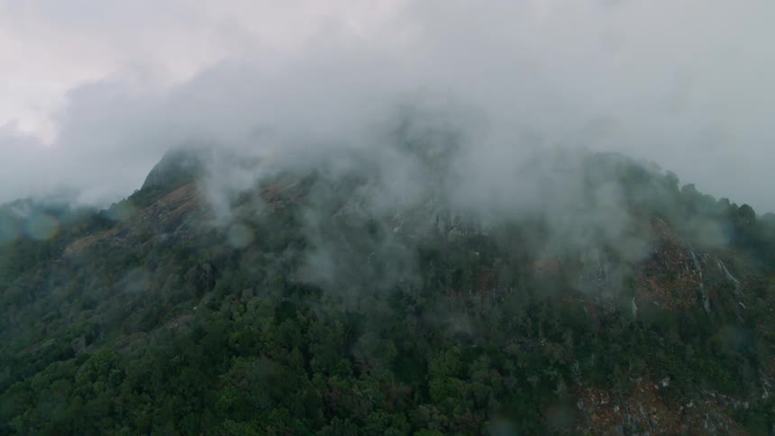 The rain clouds cover the green mountain