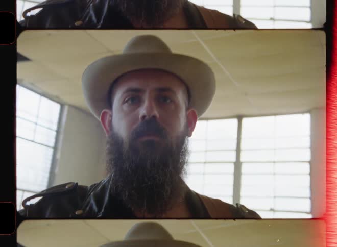 A man is standing in the room holding a guitar