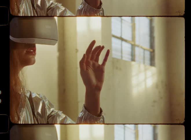 A woman is moving her hands as she uses a virtual reality headset