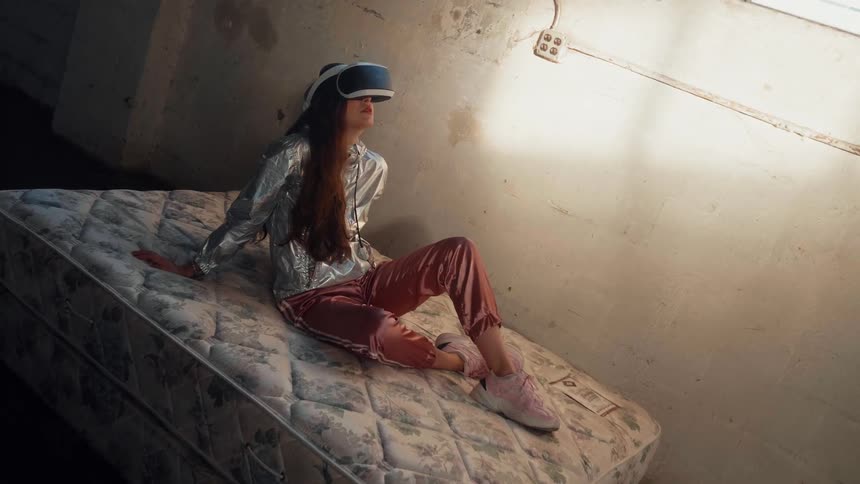 A woman lays in bed using a virtual reality headset