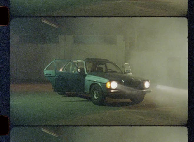 Car is parked with its doors open and headlights on