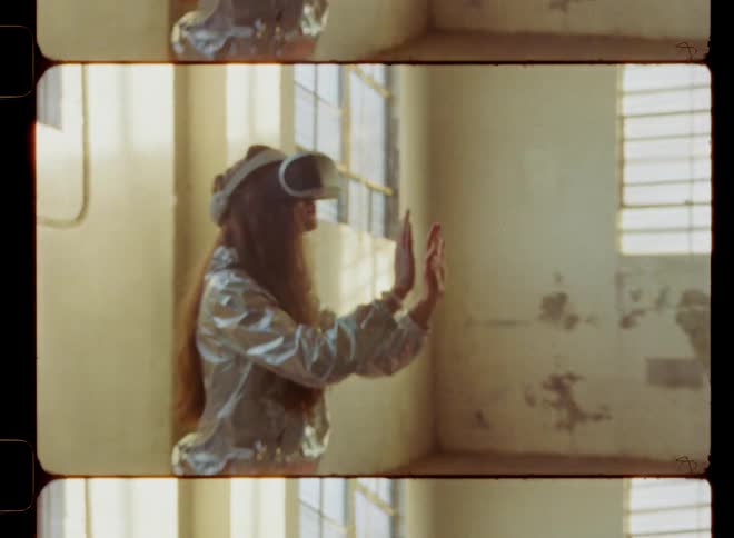 A woman raises her hands in front of her wearing a virtual reality headset