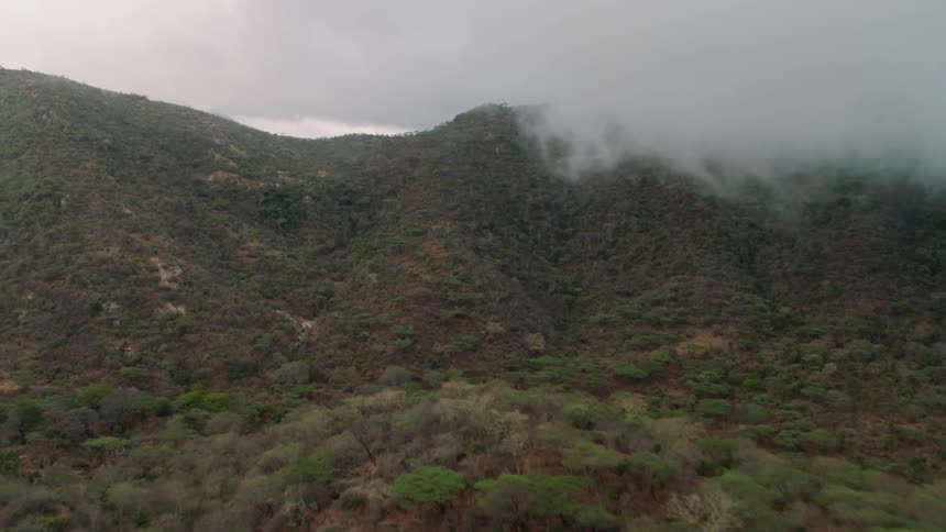 The hills ahead have the clouds rolling over the top