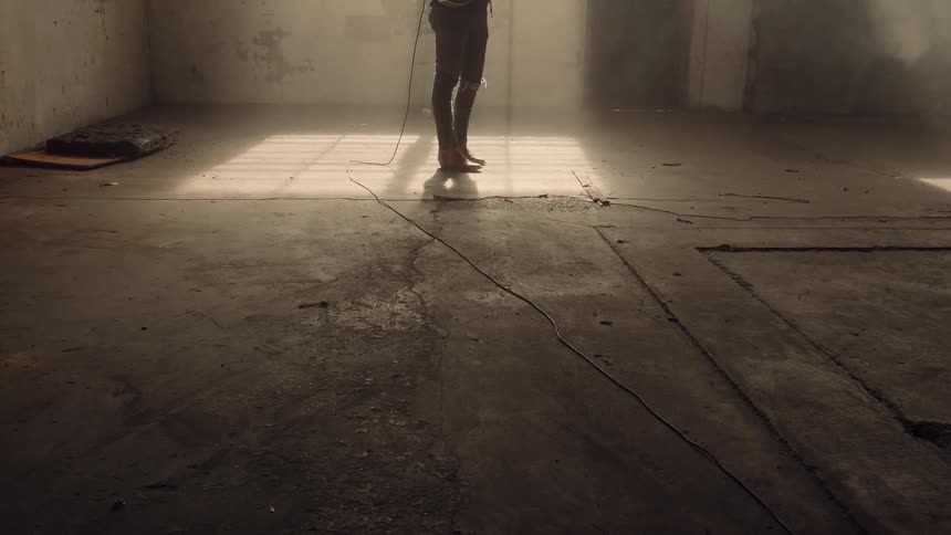 A guitarist plays in a run down building