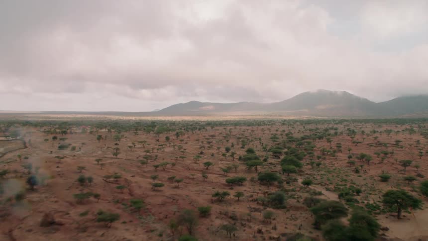 Clouds are drifting across a barren landscape and hills in daylight