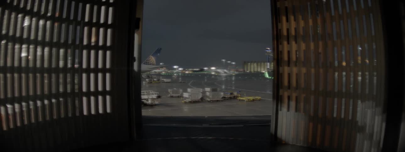 Open window shows an airport with parked vehicles and airplanes
