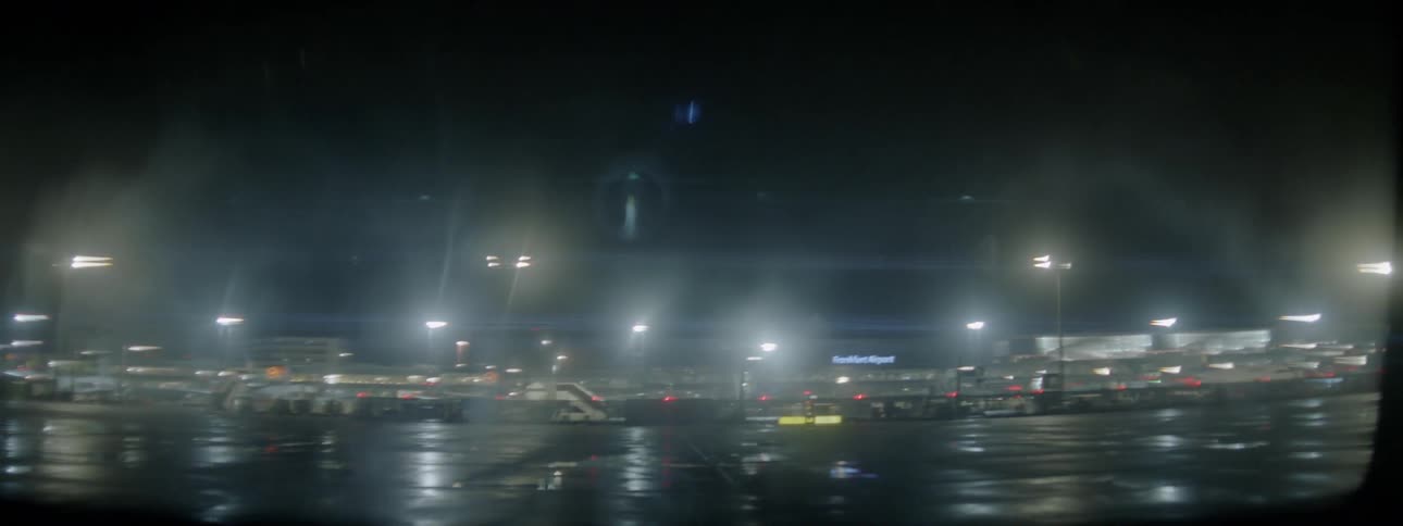 The runway is covered with lights and rain