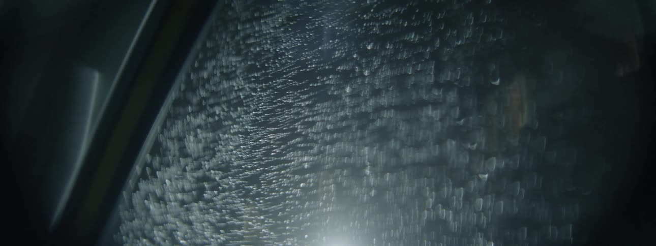 The light from a lamp shines on the glass at night