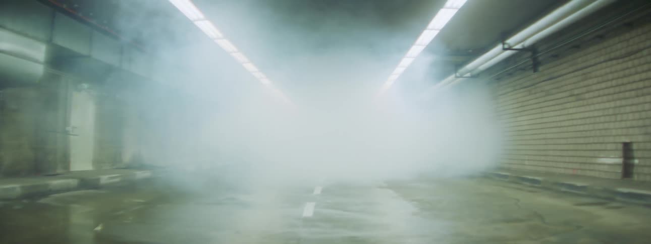 A person rides a bike through a smoky tunnel