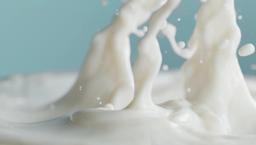 Strawberries fall into a creamy liquid